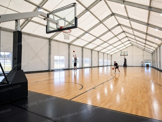 Wide shot of athletes training on hardwood court inside modular sports hall