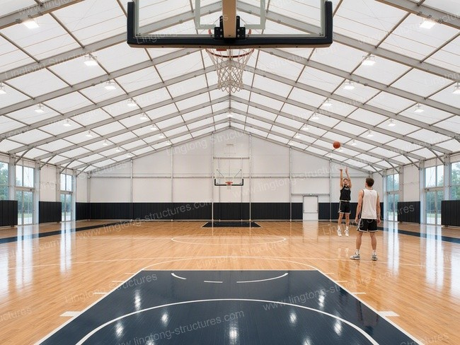 Two players practice shooting in spacious indoor basketball arena tent