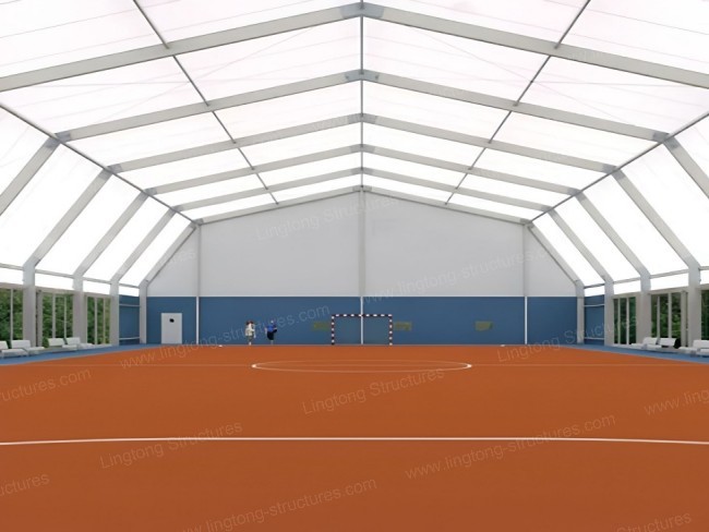 Sports tent configured for tennis or volleyball with high clear height and column-free space