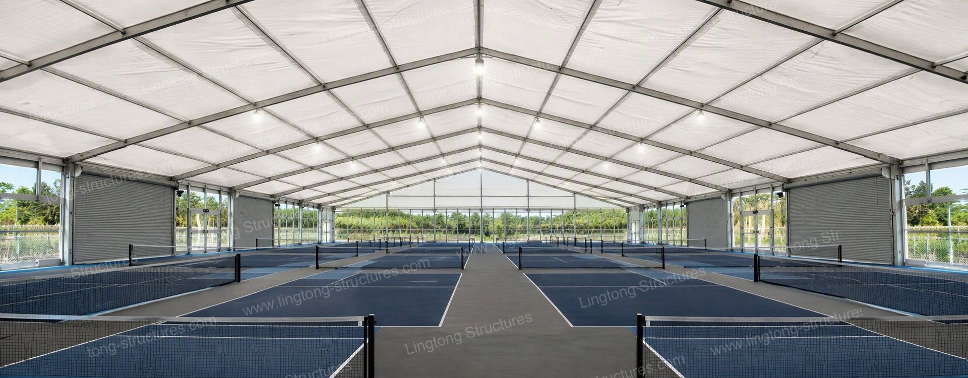 Indoor pickleball court under a clear span tent